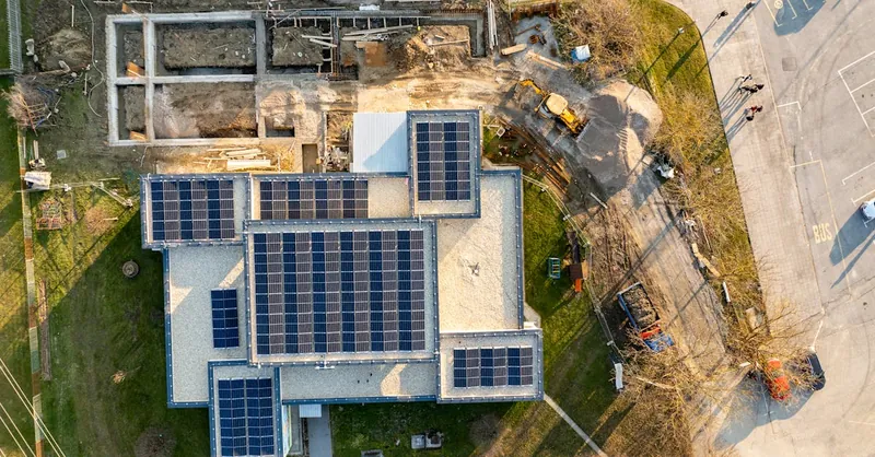 Top-down view of a building with solar panels and construction work in progress.