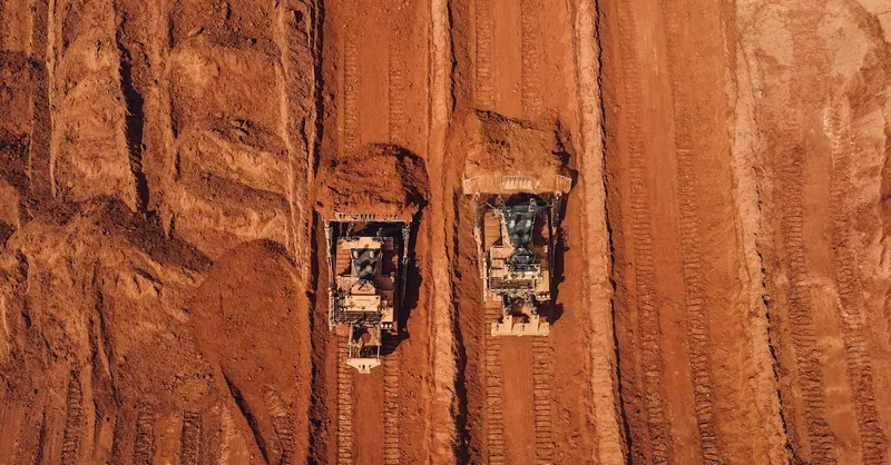 Aerial shot of two tractors excavating red earth, showcasing construction and mining machinery in Brazil.