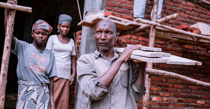 A diverse group of workers actively engaged in construction at a brick building site.