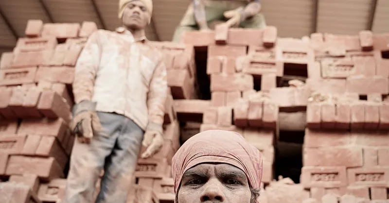 Three men working at a brick construction site, conveying industrial labor.
