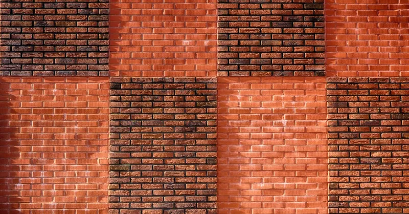 Close-up of a red brick wall featuring a geometric pattern, highlighting urban architecture design.
