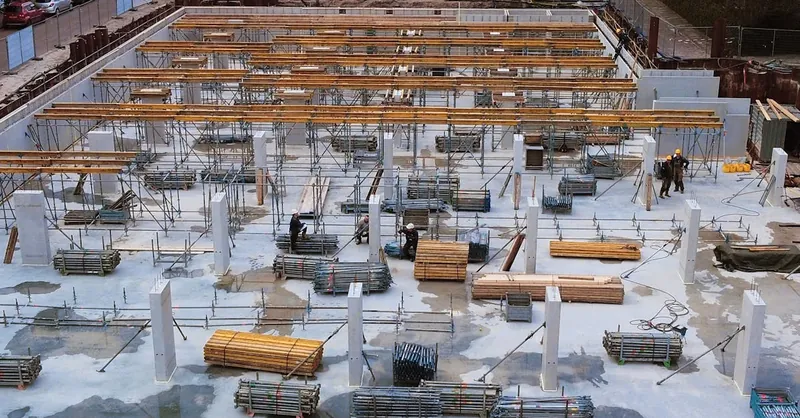 A busy construction site with scaffolding, steel structures, and workers.