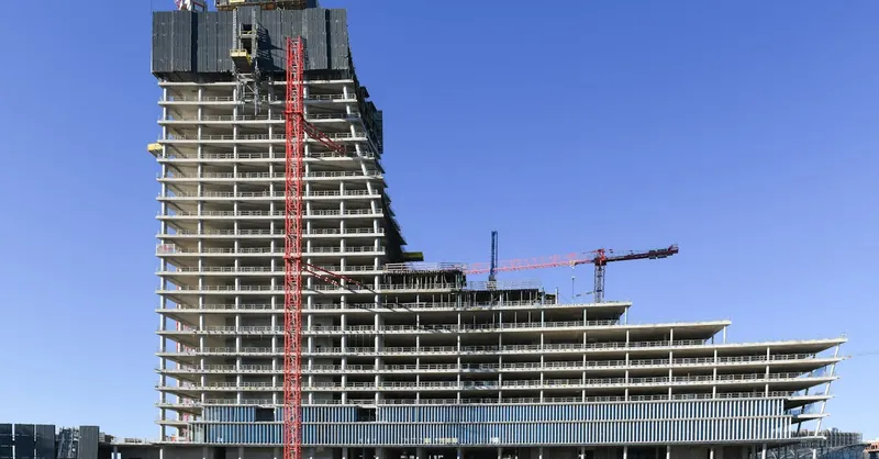 Aerial view of a modern high-rise under construction in Hamburg, featuring cranes and concrete structures.