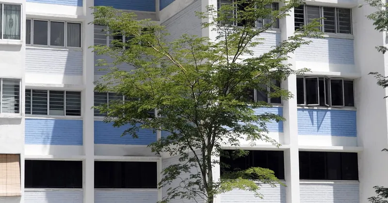 Modern residential building exterior with greenery in Singapore.